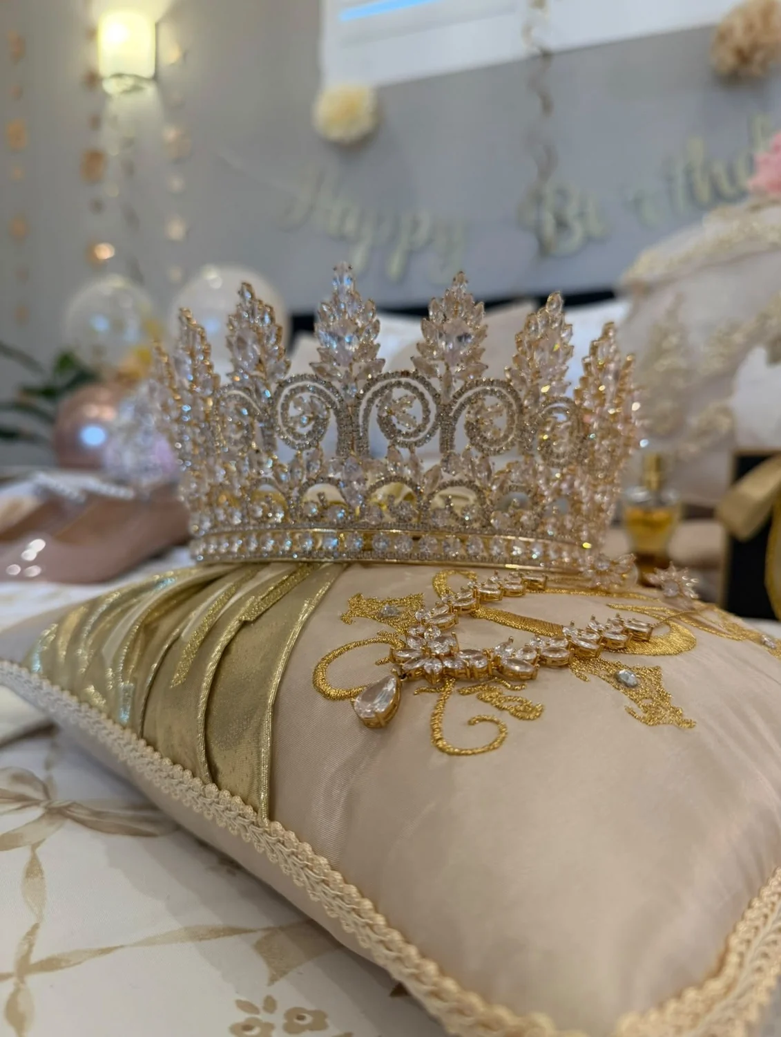 Corona de quinceañera sobre cojín con detalles dorados