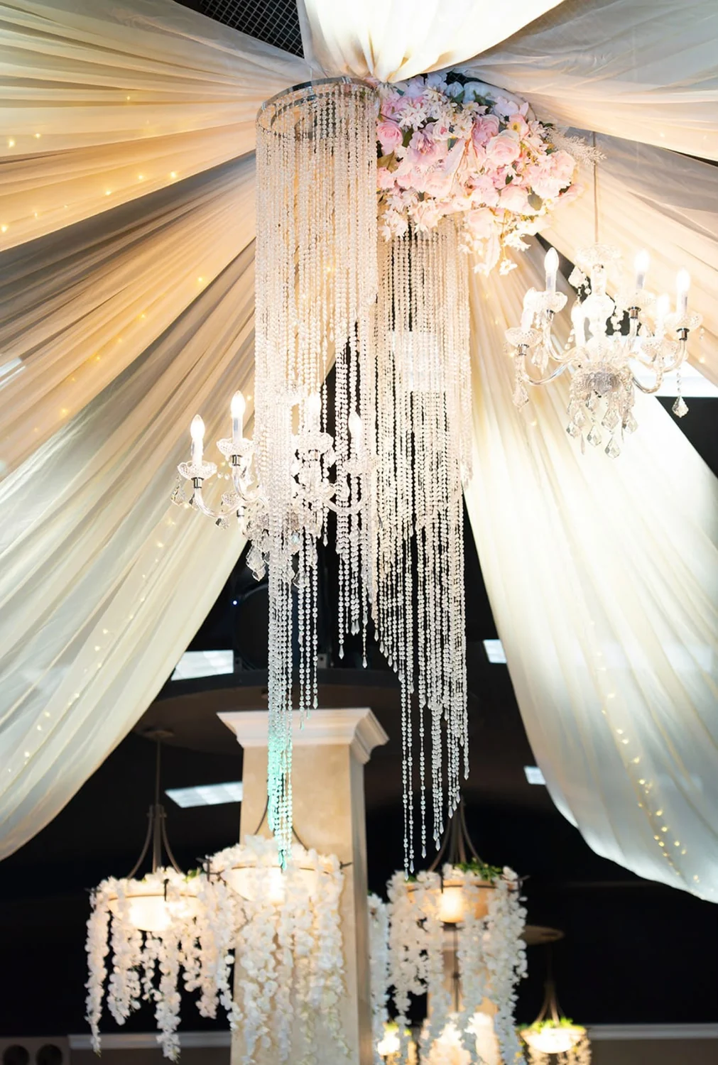Decoración de salón con candelabro, cristales y telas iluminadas