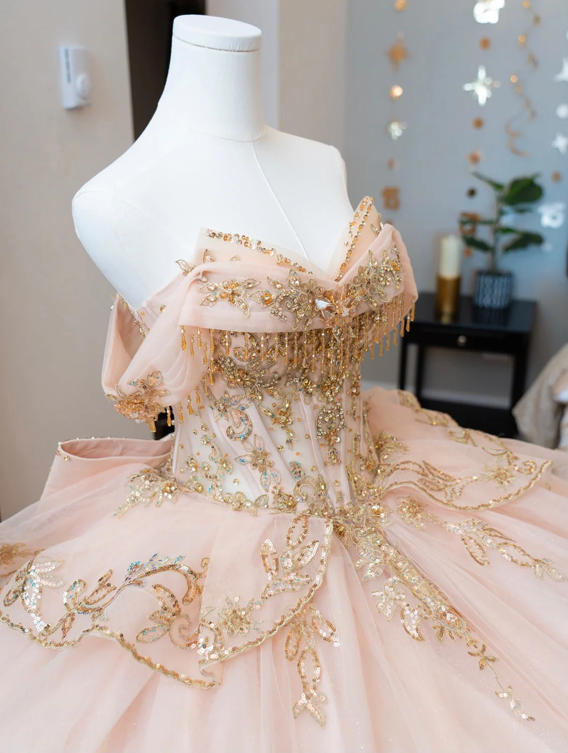 Detalle de vestido de quinceañera con bordado y pedrería dorada